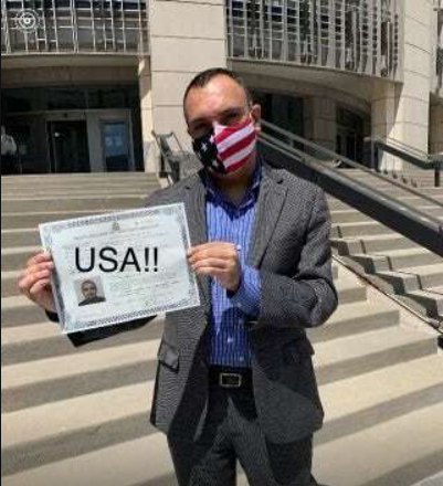 Michael Bartlett holding his U.S. citizenship certificate